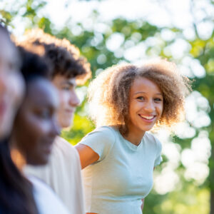 Smiling young woman with curly hair outdoors