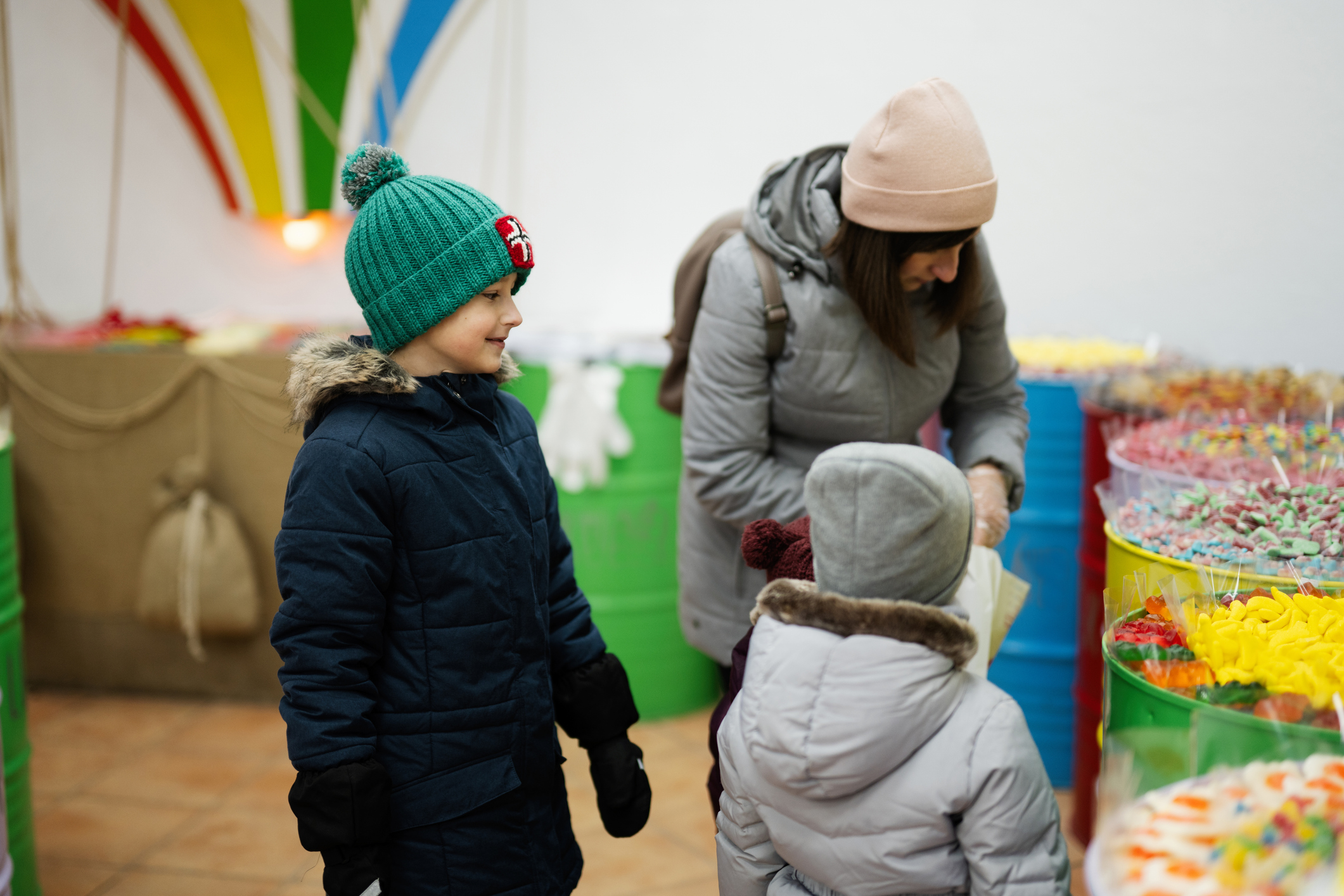 Children selecting candy from colorful market bins