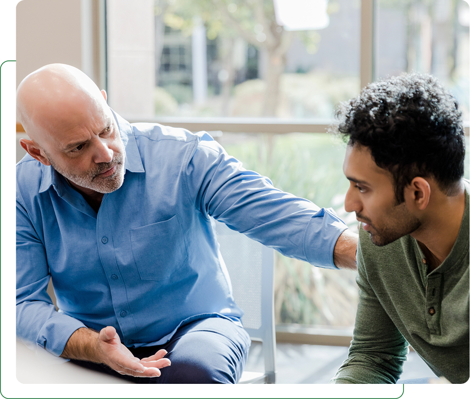 Counselor comforting young man in therapy session