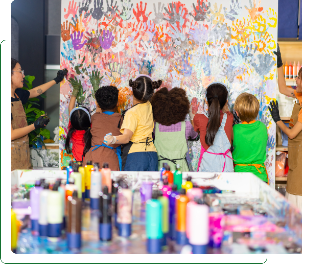 Children creating large colorful handprint mural