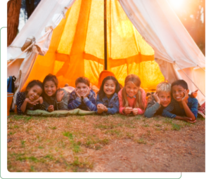 Group of children smiling in camping tent