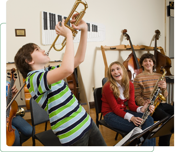 Boy playing trumpet while classmates laugh