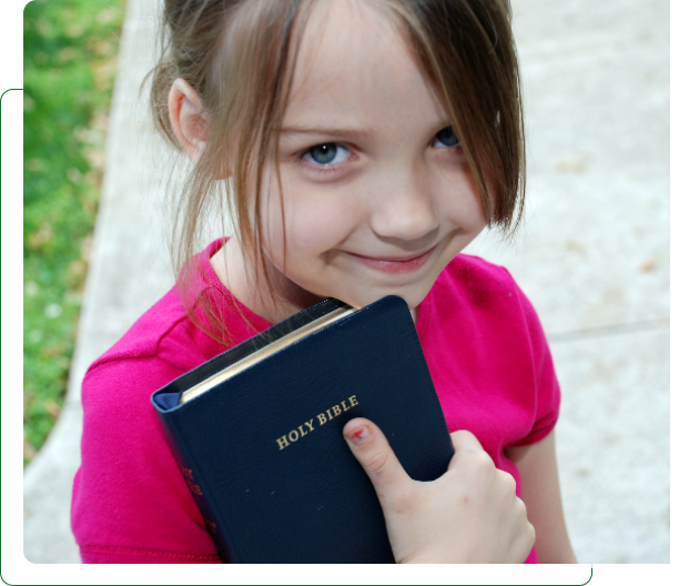 Smiling girl holding a Holy Bible