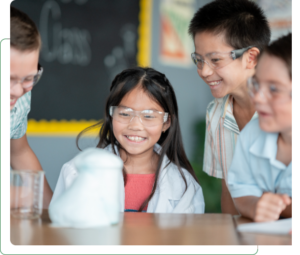 Children in goggles watching a classroom science experiment