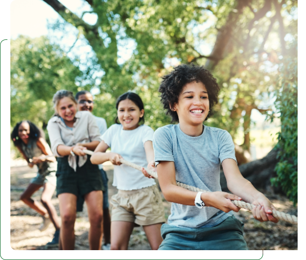 Children playing tug-of-war outdoors in park